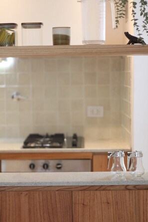 A kitchen with a wooden countertop, a stove, and a tiled backsplash. - Family Chalet Boutique (Luján de Cuis)