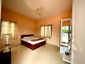 A bedroom with a bed, curtains, a water dispenser, a mirror, and a view of the outside. - Bricknest Homes (Mysore)