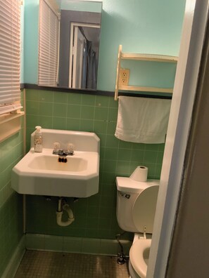 A small bathroom with a sink, toilet, and a mirror. - Cozy Three Bedroom House In Scenic Rusk. (Rusk)