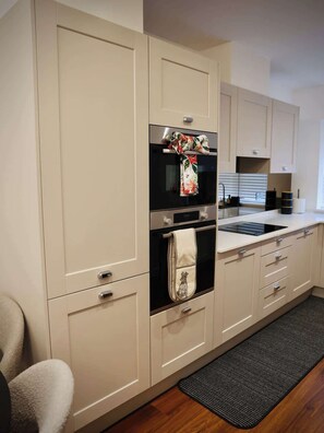 Een moderne keuken met een ingebouwde oven, een roestvrijstalen koelkast en een spoelbak.