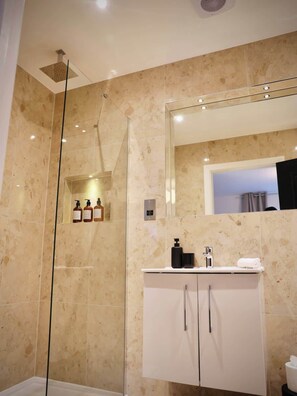 A modern bathroom with a glass shower enclosure, a large mirror, and a white vanity with a sink. - Large 4BR Home w/3 Baths I Sleeps 9 I Free Parking (South Croydon)