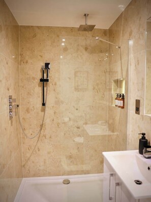 Een moderne badkamer met een douche, een bad en een wastafel.