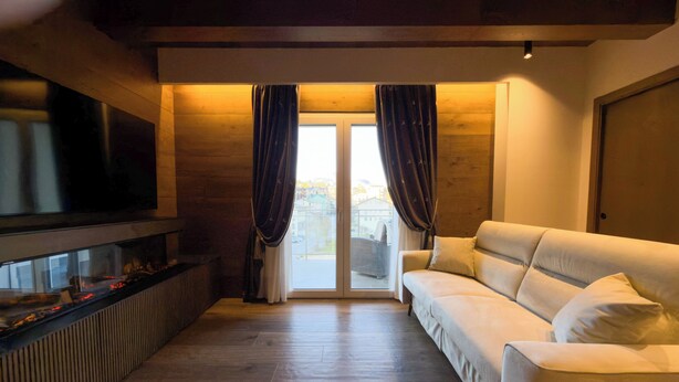 Una sala de estar con un sofá, un televisor de pantalla plana y una chimenea.