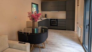 A modern kitchen with dark cabinets, a built-in oven, and a coffee maker. - New 2CH gîte with private pool - Peace, nature & comfort 10min from Bergerac (Lembras)