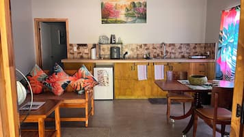 A compact kitchen with a dining area, a refrigerator, a microwave, and a sink.