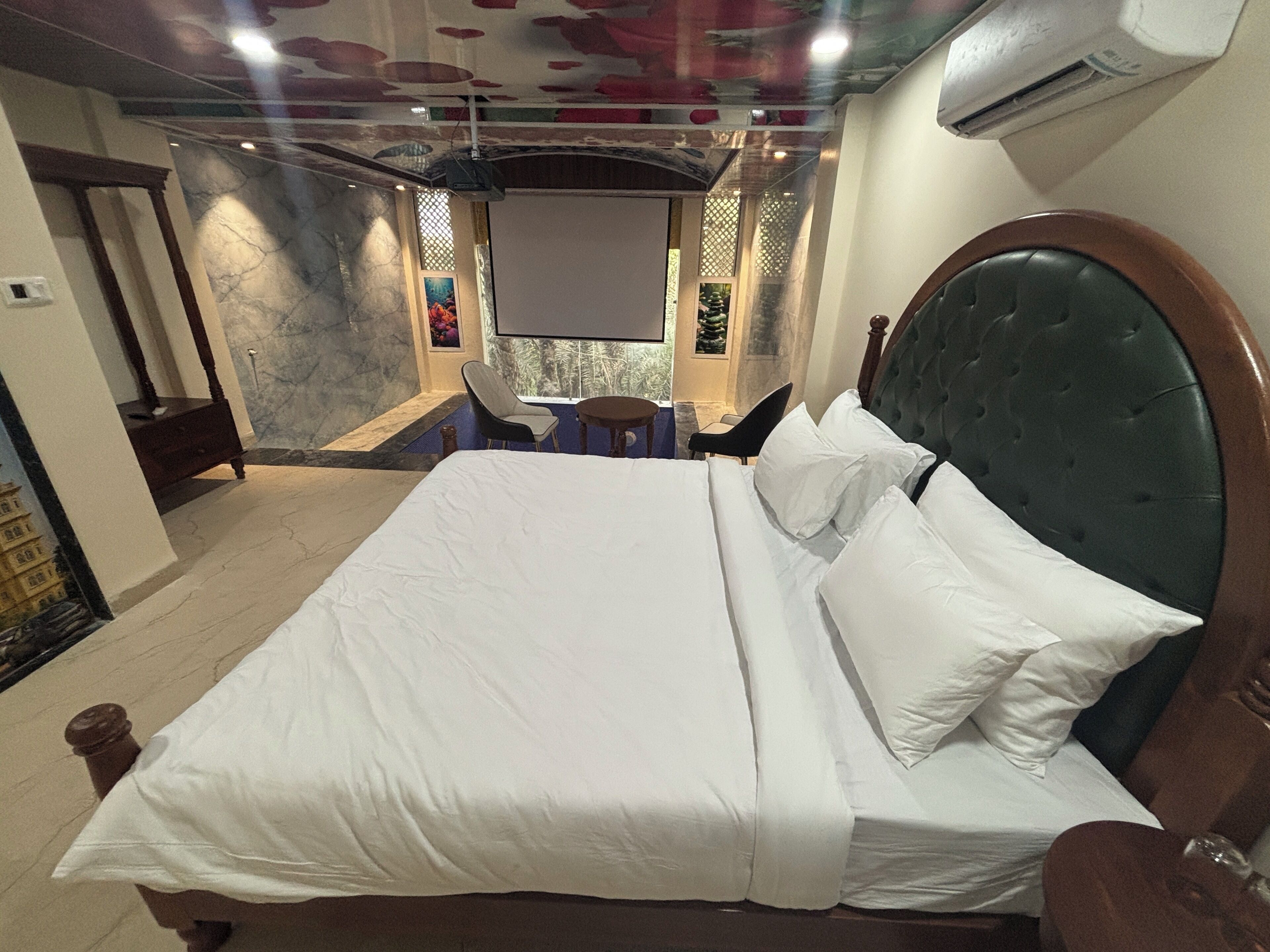 Ein Hotelzimmer mit einem großen Bett, einem kleinen Schreibtisch und einem Stuhl.