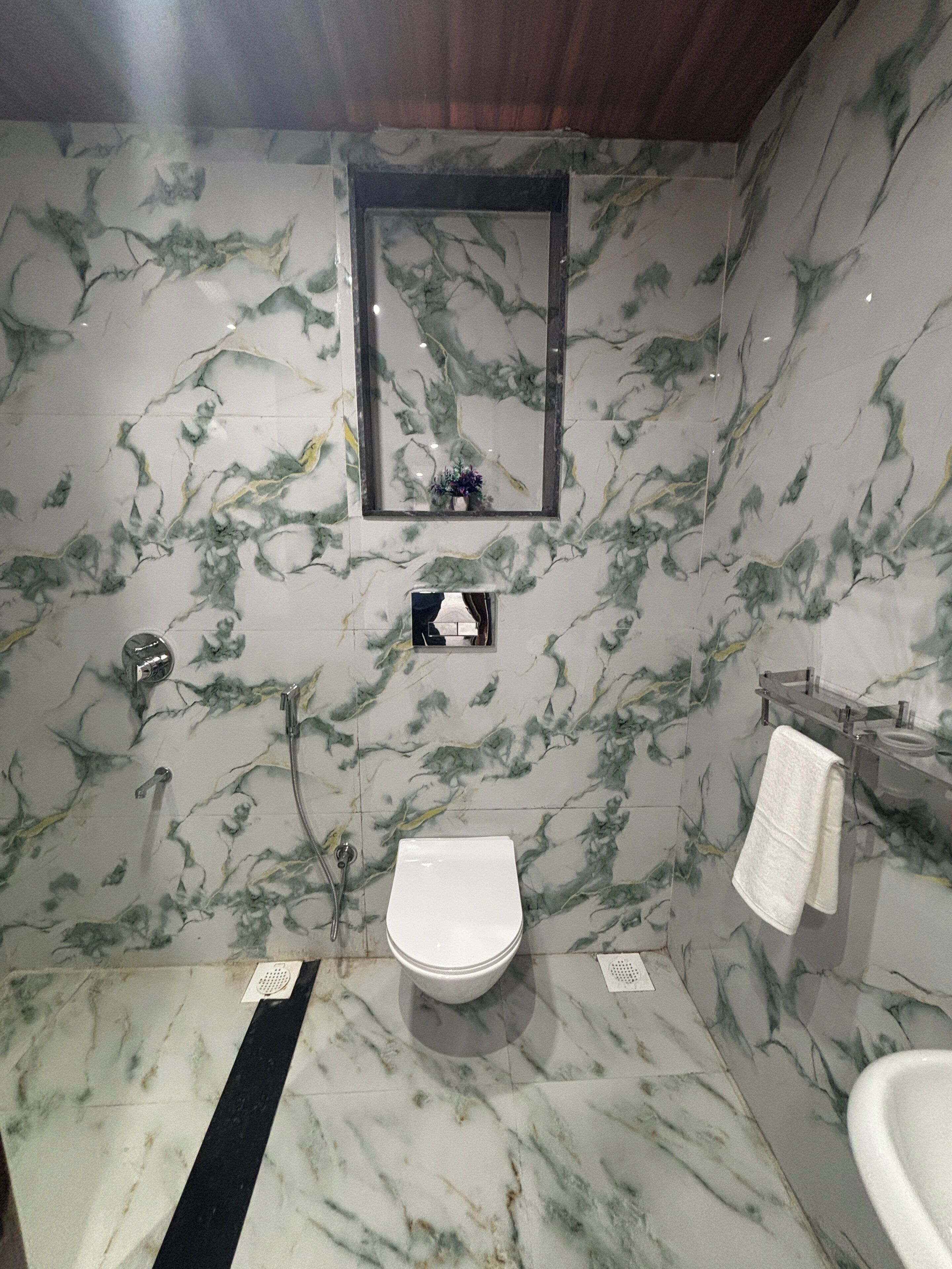 A bathroom with a toilet, sink, and mirror.