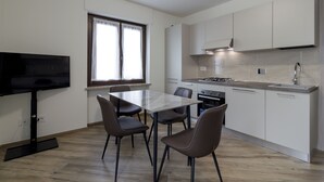 A modern kitchen with a dining area, a TV, and a window. - Sonia Holiday Home - Jessica Apartment combines intimacy comfort and coziness (Pont-Saint-Martin)