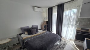 Een moderne slaapkamer met een bed, een bureau en een inbouwoven.