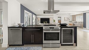 Una cocina moderna con horno empotrado, lavavajillas y una campana extractora de acero inoxidable.