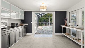 Una cocina moderna con un ventanal que da a una zona de piscina.