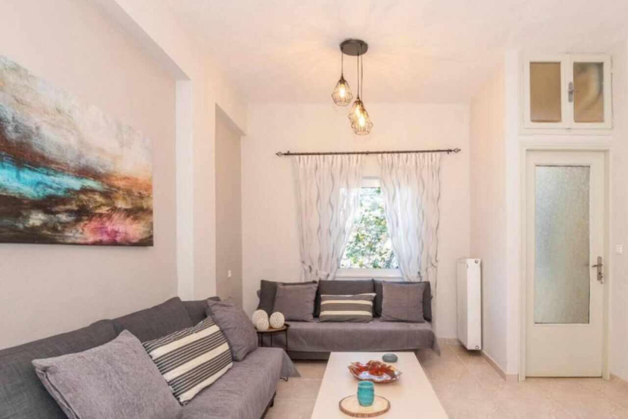 A living room with a grey sofa, a coffee table, and a painting on the wall.