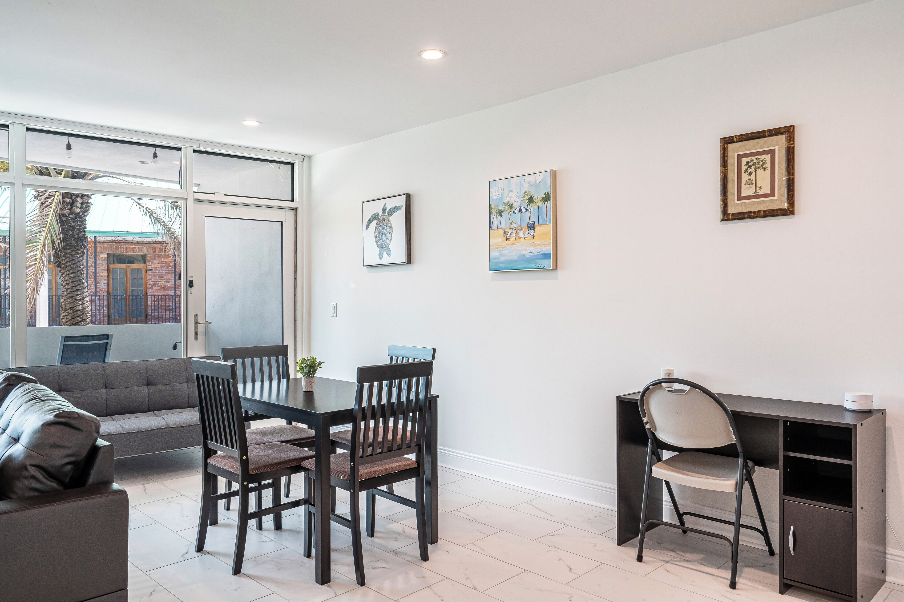 A modern living room with a dining area, a sofa, a table, and a desk.