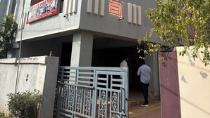 A multi-story building with balconies, a gated entrance, and a sign advertising premium services. - Sam Premium  (Bhubaneshwar)
