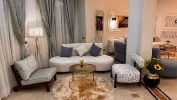 A modern living room with a sofa, armchair, coffee table, and decorative elements.