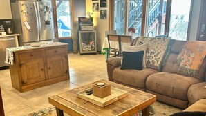 A cozy living room with a wooden coffee table, a brown sofa, and a patterned rug. - Hillside Haven Anchorage (Anchorage)