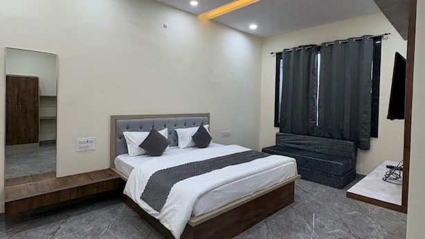 A modern bedroom with a bed, ceiling fan, and a large mirror. - Jodhana Raj Hotel & Restaurant (Ajmer)