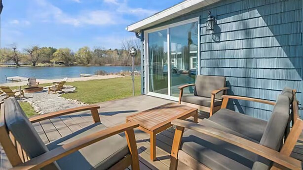 A patio with outdoor furniture, a pool, and a view of a lake. - Peaceful 3-bedroom cottage on the lake (Trufant)