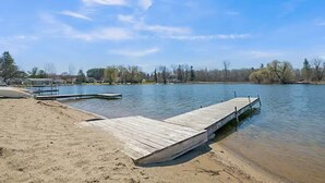 A wooden dock extending into a calm lake, surrounded by trees and a clear sky. - Peaceful 3-bedroom cottage on the lake (Trufant)