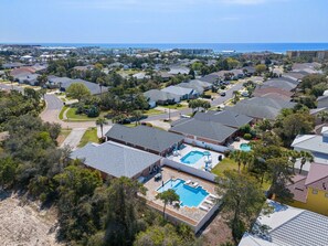 A residential area with multiple houses, a swimming pool, and a view of the ocean. - White Shores, Pet Friendly, Beautiful massive Pool, Short walk to the Beach. (Miramar Beach)