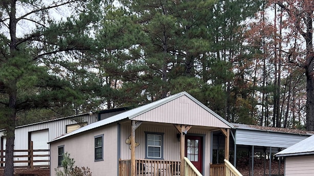 A single-story house with a front porch, a small staircase, and a fenced yard. - Cozy Cabin on Angelina River near Lake Sam Rayburn-Pool, Boat Parking, Fishing (Jasper)