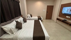 Habitació d'hotel amb dos llits, televisió i una porta.