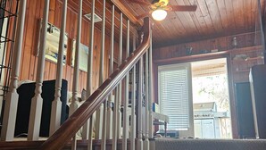 A wooden staircase with white balusters, carpeted steps, and a ceiling fan. - Beautiful house on Sunset Beach in Treasure Island with outdoor balcony. (Treasure Island)