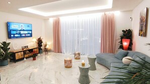 A modern living room with a flat-screen TV, a sofa, a coffee table, and a staircase. - Alma Nomada Luxury Villa & Private Pool & BBQ & Solarium (Corralejo)