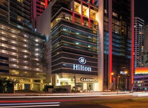 A modern hotel with a prominent Hilton logo, multiple floors, and a casino sign. - YC 1701l Apartamento 2 BDR Av Balboa (Panama City)