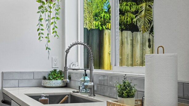 A modern kitchen with a sink, faucet, and potted plants. - Hot Tub - Firepit - Prime Location - Belmont Shore Retreat - FIFA 2026 (Long Beach)