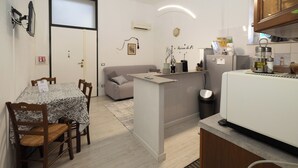 Et kompakt køkken med spiseplads, en sofa og en lille ø.