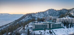 Ein Hotelkomplex mit mehreren Gebäuden, umgeben von schneebedeckten Bergen und Bäumen.