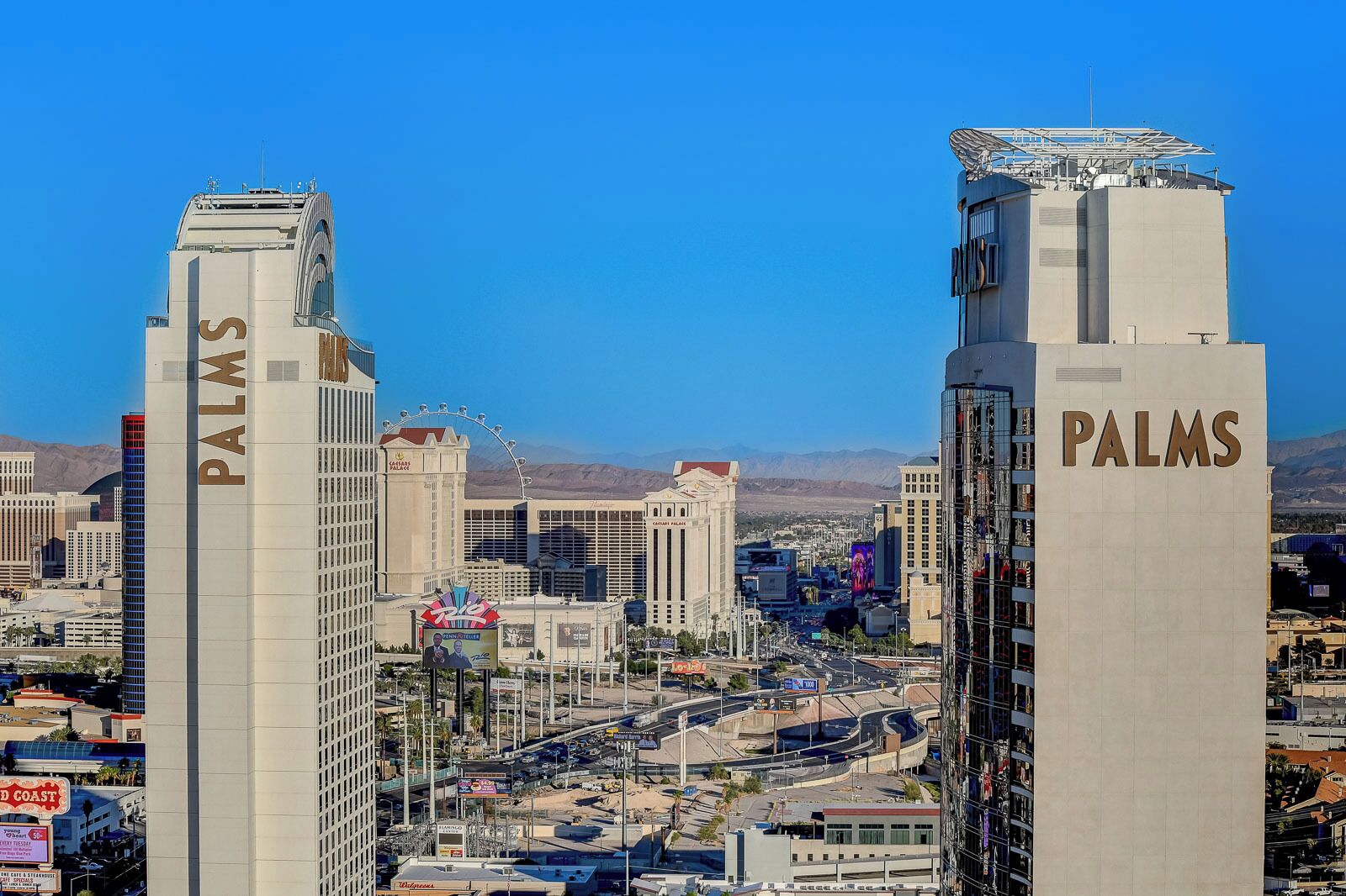 Two prominent buildings with 'PALMS' signage, surrounded by a cityscape with a clear sky.
