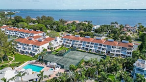 Un resort con edificios de varios pisos, una cancha de tenis y una piscina.