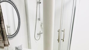 A modern bathroom with a washing machine, sink, and shower. - One Bedroom Flat D Kentish Town (London)