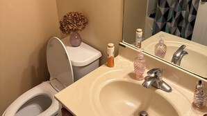 A bathroom with a toilet, sink, and mirror. - Spacious 4-bedroom house in fantastic Marietta with AC (Marietta)
