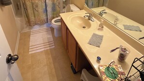 A bathroom with a beige sink, mirror, and shower curtain. - Spacious 4-bedroom house in fantastic Marietta with AC (Marietta)