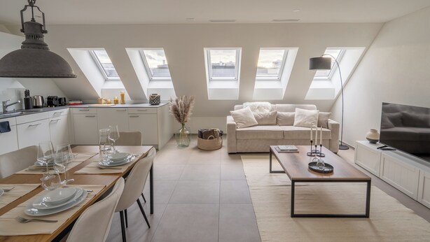 Eine moderne Wohnung mit Essbereich, Küche, Wohnzimmer und Fernseher.