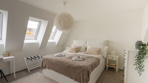 Ein modernes Schlafzimmer mit einem großen Bett, einem Schreibtisch und einem Fenster.