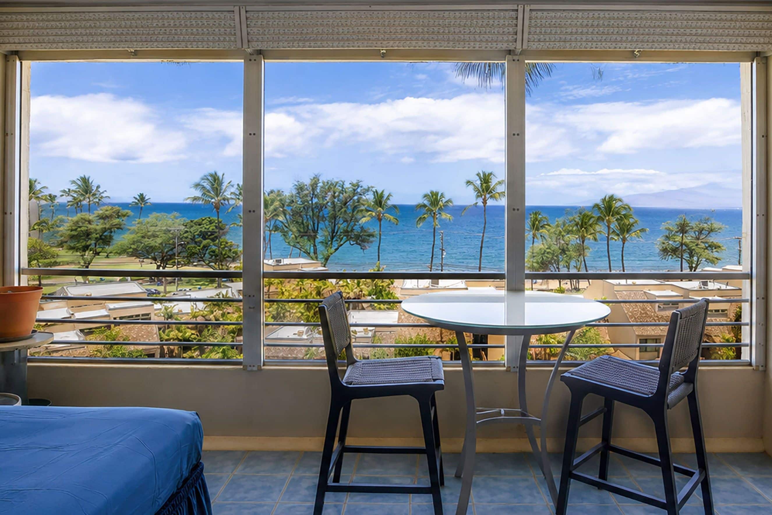 Un balcon avec vue sur l’océan et les palmiers.