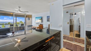 Una cucina moderna con un'isola grande, un'area pranzo con vista e una porta scorrevole in vetro che dà su un balcone.