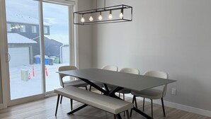 A modern dining area with a rectangular table, bench, and pendant light fixture. - 
"Where the City Ends and the Mountains Begin." (Calgary)