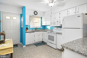 A kitchen with white cabinets, a microwave, an oven, and a refrigerator. - Adorable 2-bedroom townhome with outdoor POOL in Ocean City (Ocean City)