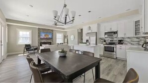 A spacious kitchen with white cabinets, a central island, and modern appliances. - Luxury 7 bedroom Beach Block Steps off the Boardwalk with Parking & Ocean Views (Ocean City)