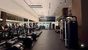 A gym with various exercise equipment, including treadmills, weight machines, and free weights. - NEW amenity-rich studio near Hard rock Stadium by SLS & ICON developers (Miami)