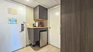 A compact kitchenette with a refrigerator, a coffee maker, and a trash bin. - 2 Queen Beds studio with AC in vibrant Honolulu near the Marina & Beach (Honolulu)