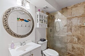 A bathroom with a large ornate mirror, a white sink, a toilet, and a glass-enclosed shower. - Kalama Terrace P-307 - 3rd-floor Walkup, 7 min Walk to Charley Young Beach, AC! (Kihei)