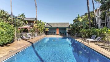 A swimming pool with lounge chairs and a building in the background.