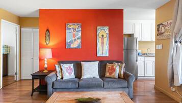 A living room with a grey sofa, a wooden coffee table, and a red accent wall.