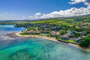Ein Küstenresort mit Strandhäusern, einem Schwimmbad und üppiger Bepflanzung.